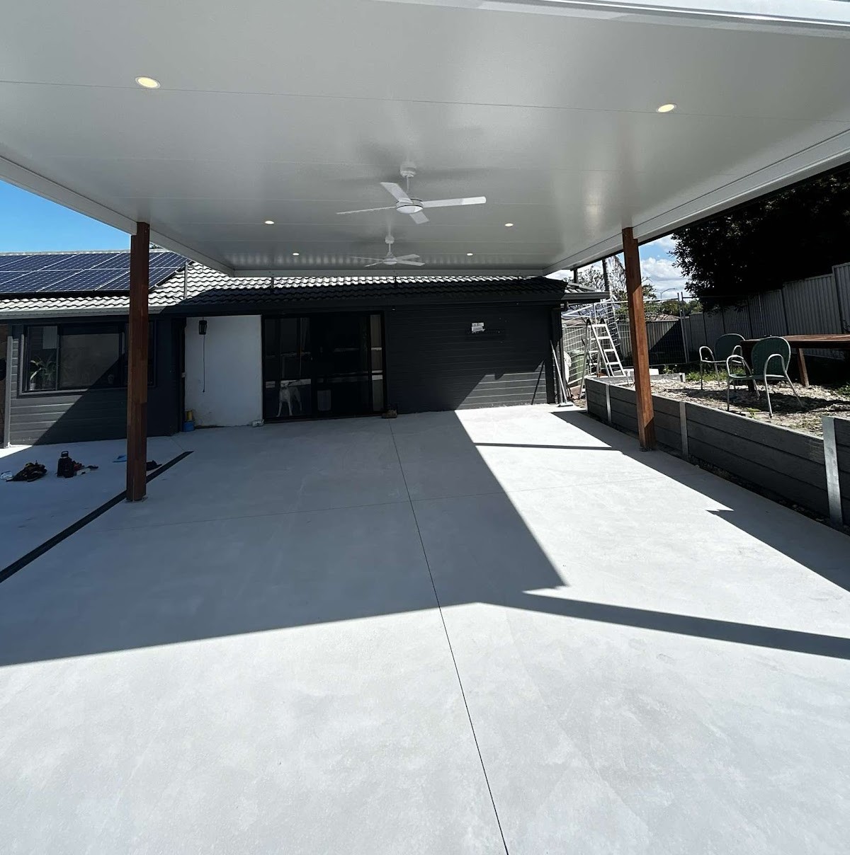 Patio roof with downlights and two ceiling fans over a concrete slab